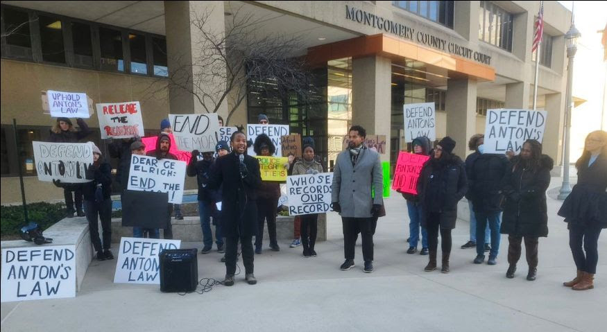 Protestors holding signs at a press conference outside the Montgomery County Circuit Court.