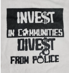 Sign reading "invest in communities, divest from police."